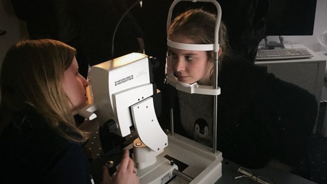 Die Medizinische Fachangestellte Pia Büning (links), Augen-Zentrum-Nordwest, demonstriert mit Jasmine Weyck aus der AHS 13 die Funktion einer Spaltlampe. (Foto: SMMP/Bauer)